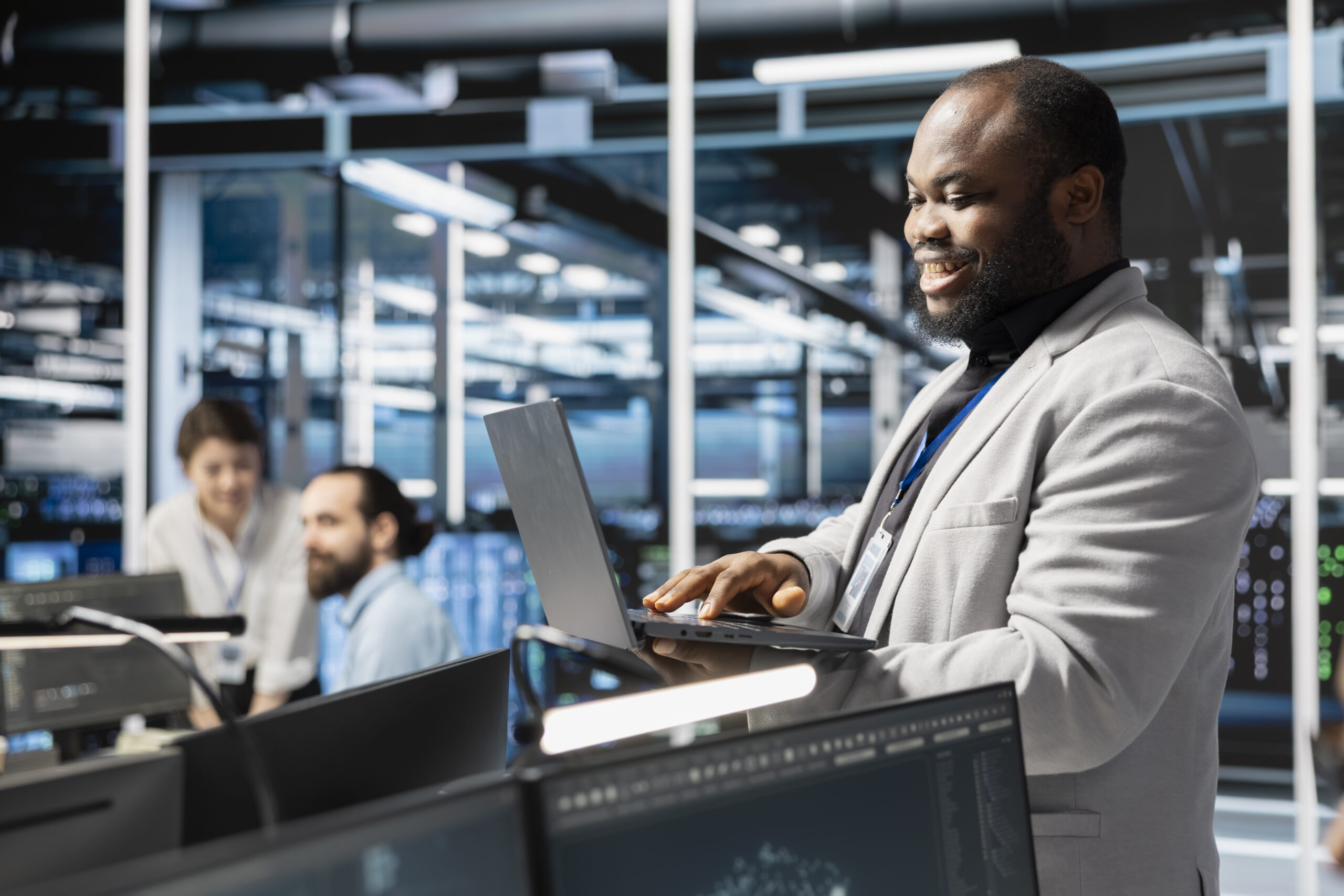 Happy data center facility admin using laptop to update supercomputers software it support company